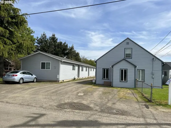 a view of a house with a yard and large tree