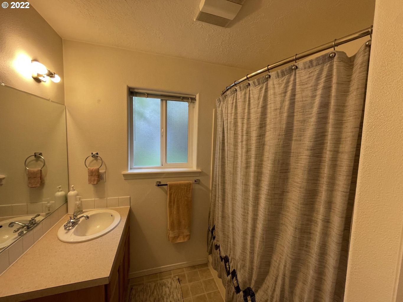 3413 Maple Lane Tillamook, OR 97141 - Photo 12 of 32 a bathroom with a sink a mirror and a shower