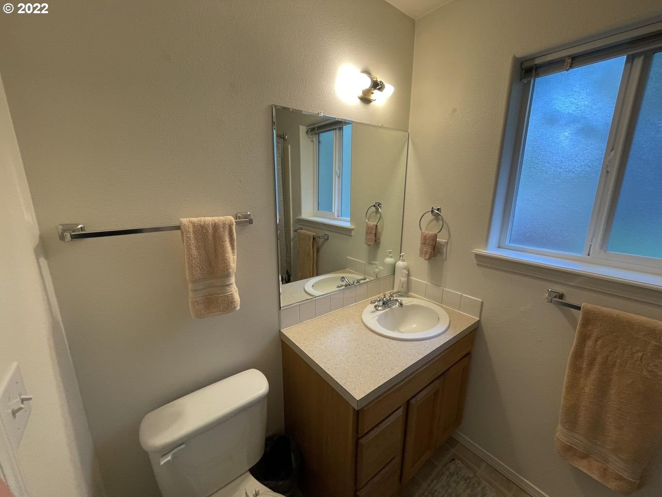 3413 Maple Lane Tillamook, OR 97141 - Photo 13 of 32 a bathroom with a toilet sink and mirror
