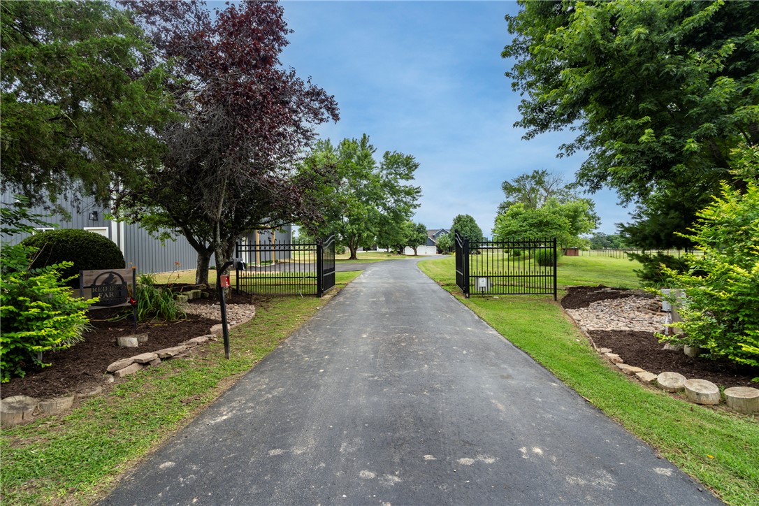 16556 East Hewitt Springs Road Springdale, AR 72764 - Photo 3 of 60 Gated driveway entry flanked by mature trees and landscaped beds