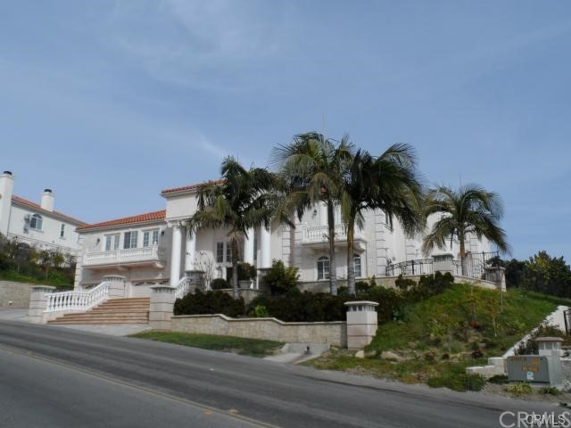 a front view of multiple houses with palm trees