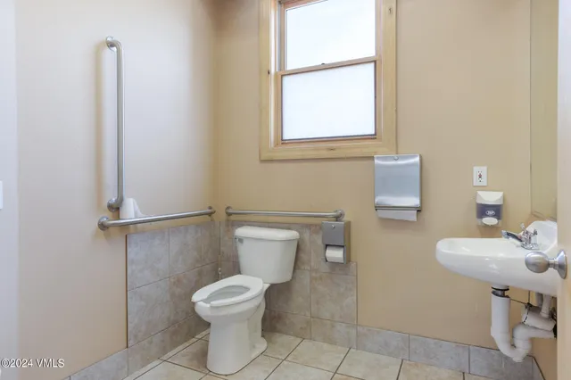 a bathroom with a toilet a sink and a window