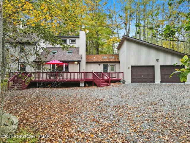a backyard of a house with wooden floor table and chairs