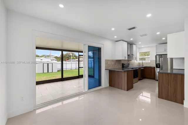 a large kitchen with a large counter top stainless steel appliances and cabinets