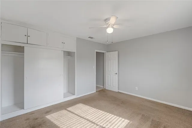 a view of an empty room with a chandelier fan