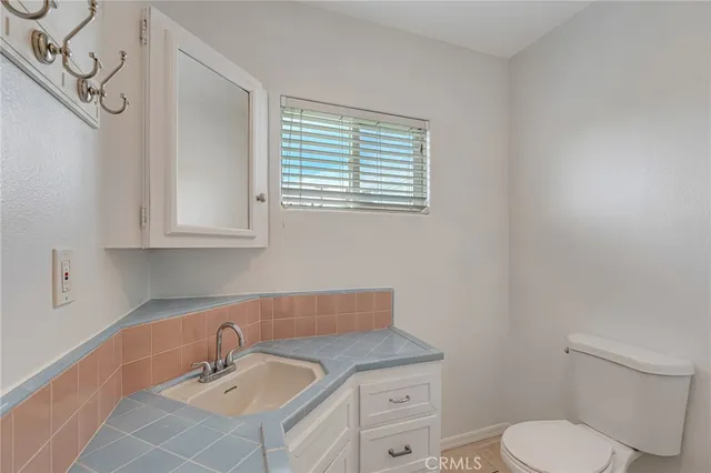 a bathroom with a toilet sink vanity and mirror