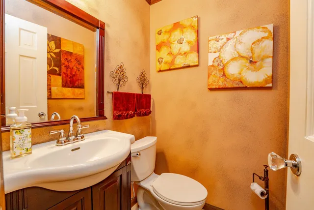 a bathroom with a sink mirror and toilet