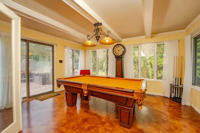 a room with pool table and windows