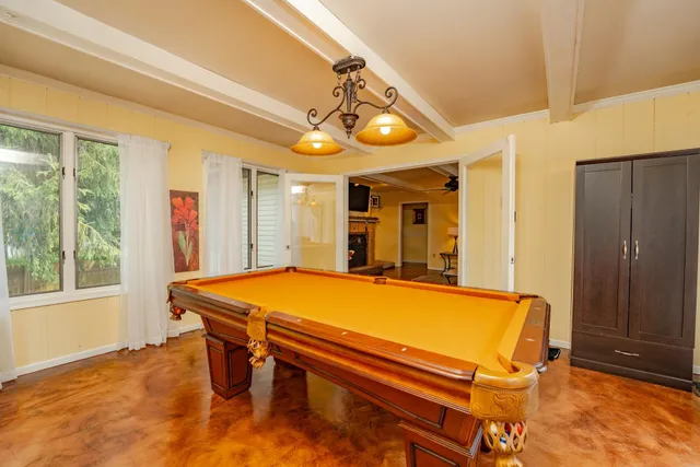 a room with pool table and windows
