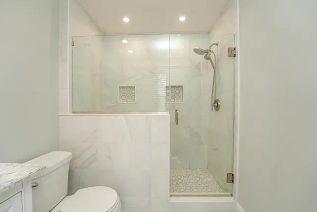 a bathroom with a shower a toilet and a sink