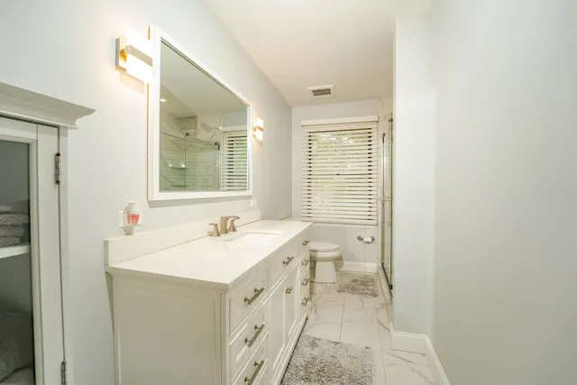 a bathroom with a sink a toilet and a mirror