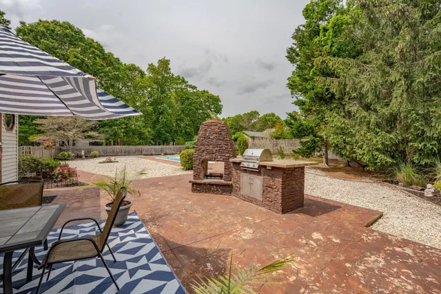 a patio with table and chairs and potted plants