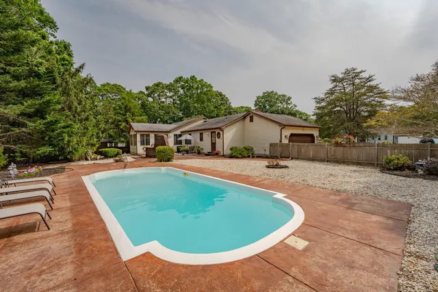 a view of house with swimming pool outdoor seating