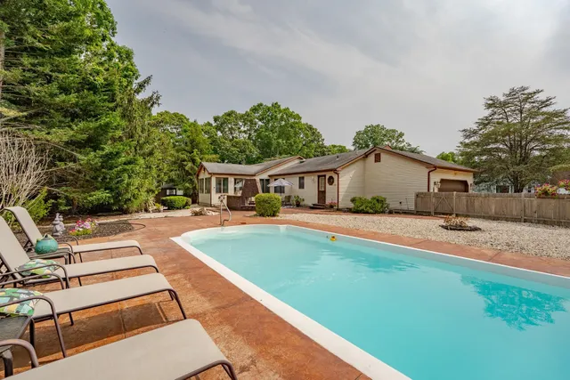 a view of house with outdoor space and swimming pool