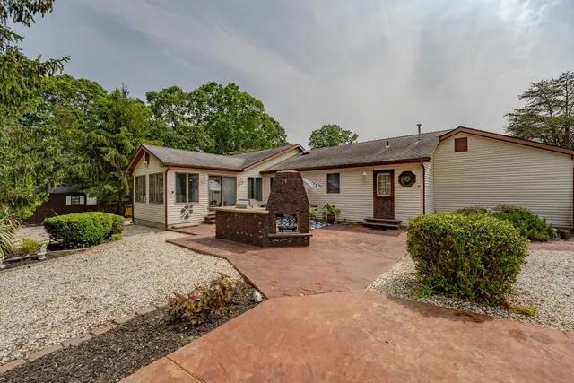 a front view of a house with yard and green space