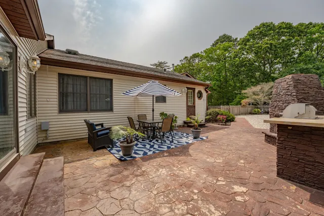 a view of a patio with table and chairs with wooden fence and plants