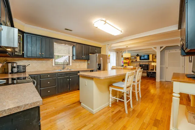 a kitchen with a sink cabinets and wooden floor