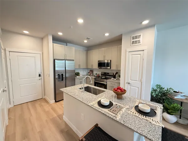 a kitchen with stainless steel appliances granite countertop a stove a sink and a refrigerator