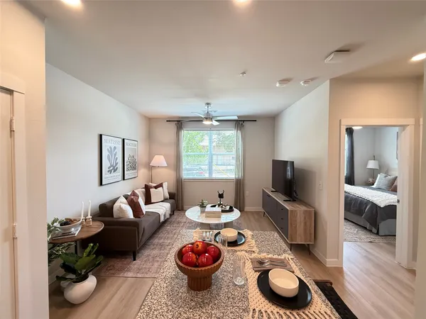 a living room with furniture a window and a flat screen tv