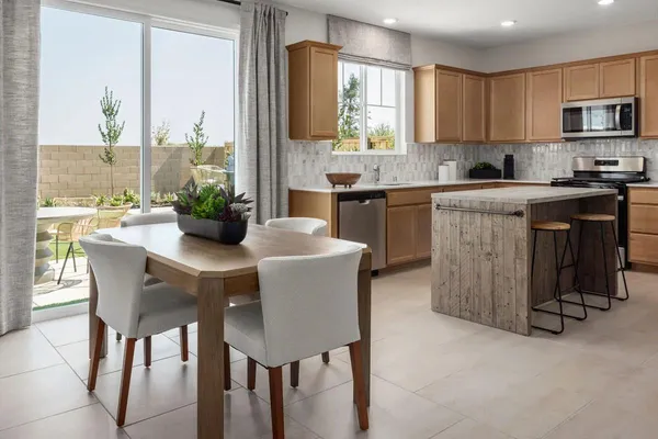 a kitchen with a table chairs sink and cabinets