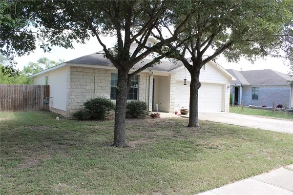 a view of a yard in front of a house with large tree