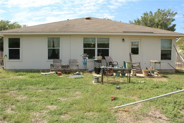 a view of backyard of house with outdoor seating and green space