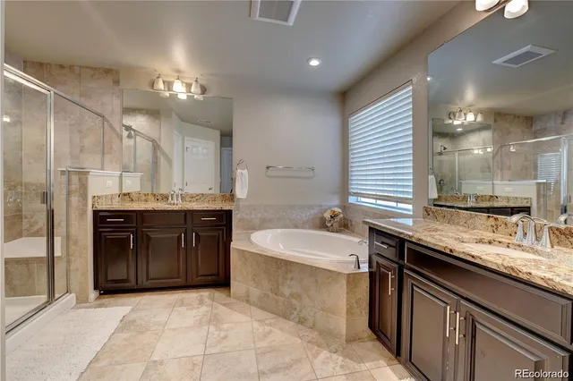 a bathroom with double vanity sinks and a mirror