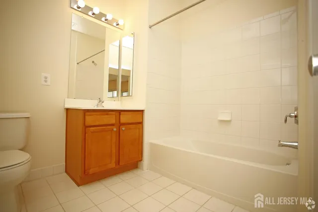 a bathroom with a granite countertop sink a mirror and a bathtub