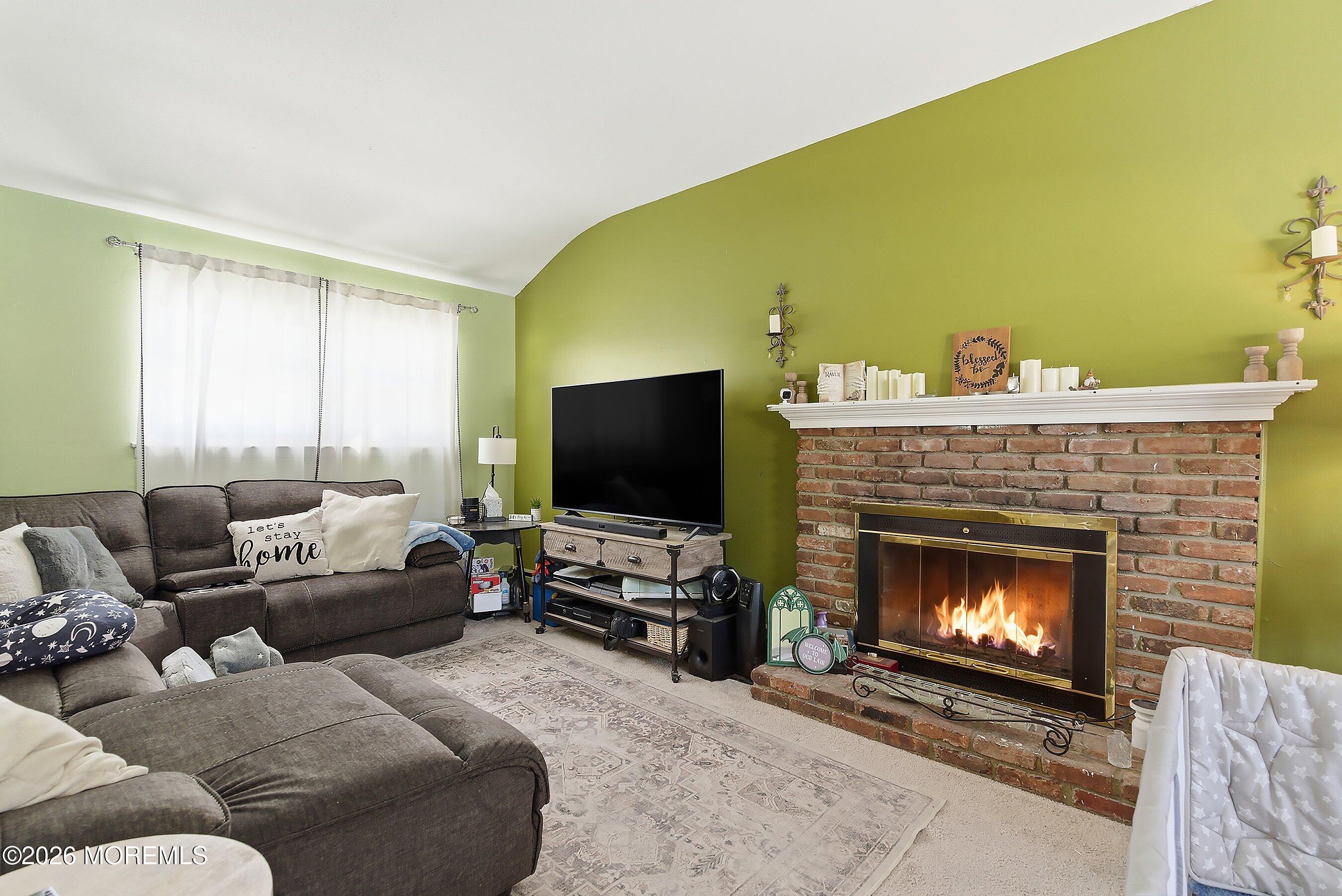 70 Oak Ridge Parkway Toms River, NJ 08755 - Photo 13 of 34 a living room with furniture a flat screen tv and a fireplace