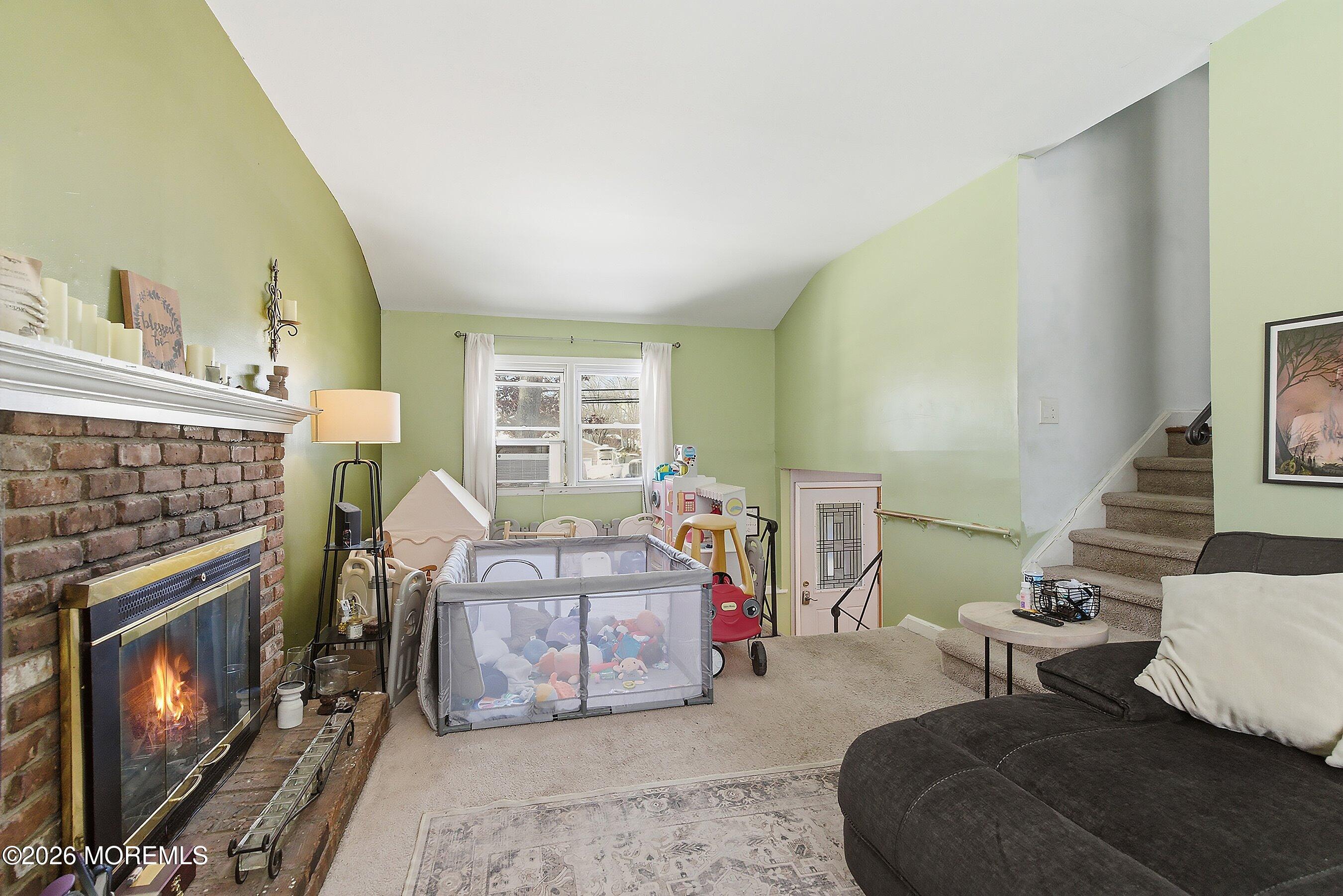 70 Oak Ridge Parkway Toms River, NJ 08755 - Photo 14 of 34 a living room with furniture a fireplace and a floor to ceiling window