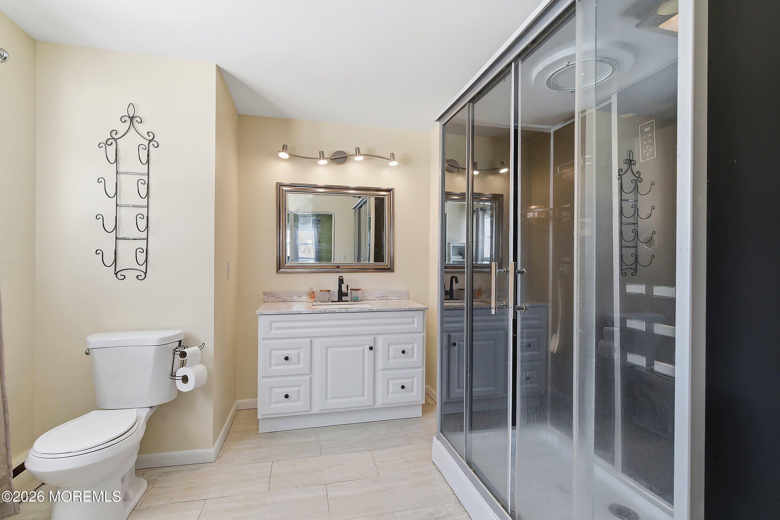 70 Oak Ridge Parkway Toms River, NJ 08755 - Photo 19 of 34 a bathroom with a toilet a sink and glass door