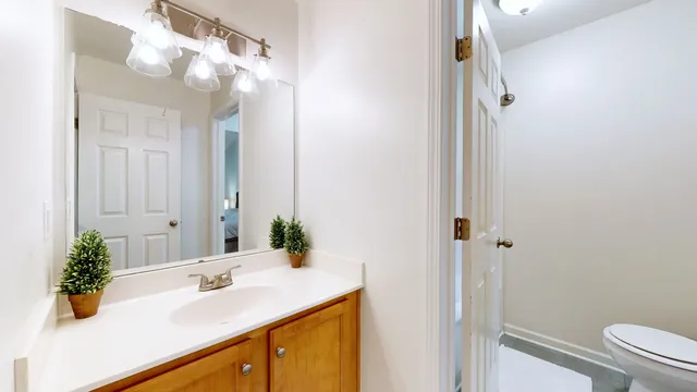 a bathroom with a sink vanity granite and toilet