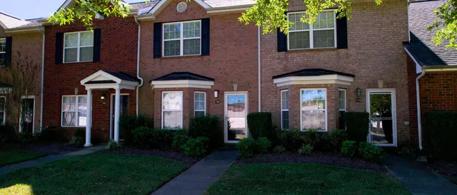 a front view of a house having yard and green space