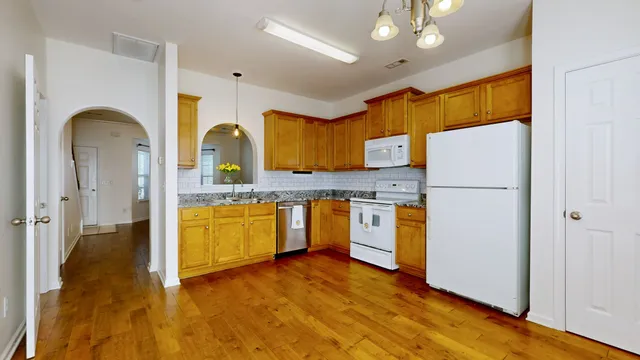 a kitchen with stainless steel appliances granite countertop a refrigerator a sink and a stove