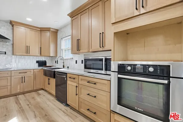 a kitchen with granite countertop white cabinets stainless steel appliances and sink
