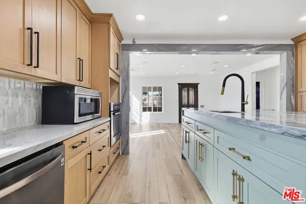 a spacious kitchen with stainless steel appliances granite countertop a lot of counter space and wooden floors