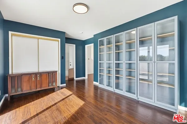 a view of a livingroom with wooden floor and a large window