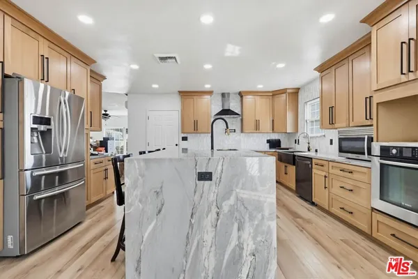 a kitchen with stainless steel appliances granite countertop a refrigerator sink and cabinets