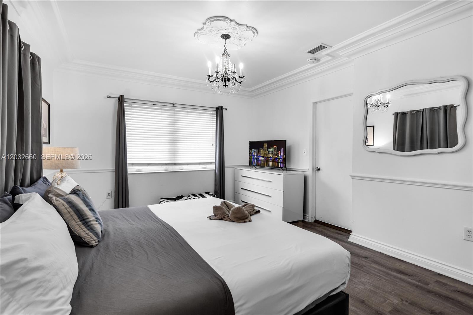520 Southwest 22nd Road Miami, FL 33129 - Photo 61 of 76 a bedroom with a bed and a chandelier