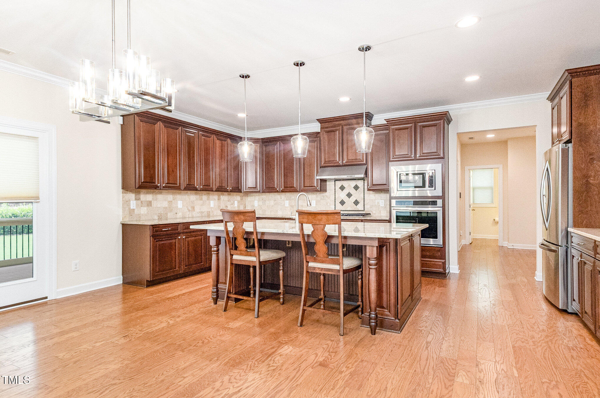 316 Matilda Place Cary, NC 27513 - Photo 11 of 69 a open kitchen with stainless steel appliances kitchen island granite countertop a table chairs and a refrigerator