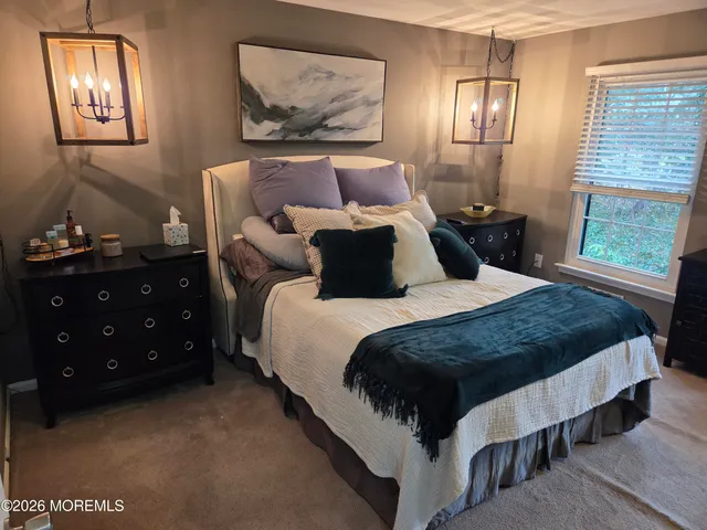 a large bed sitting in a bedroom next to a window