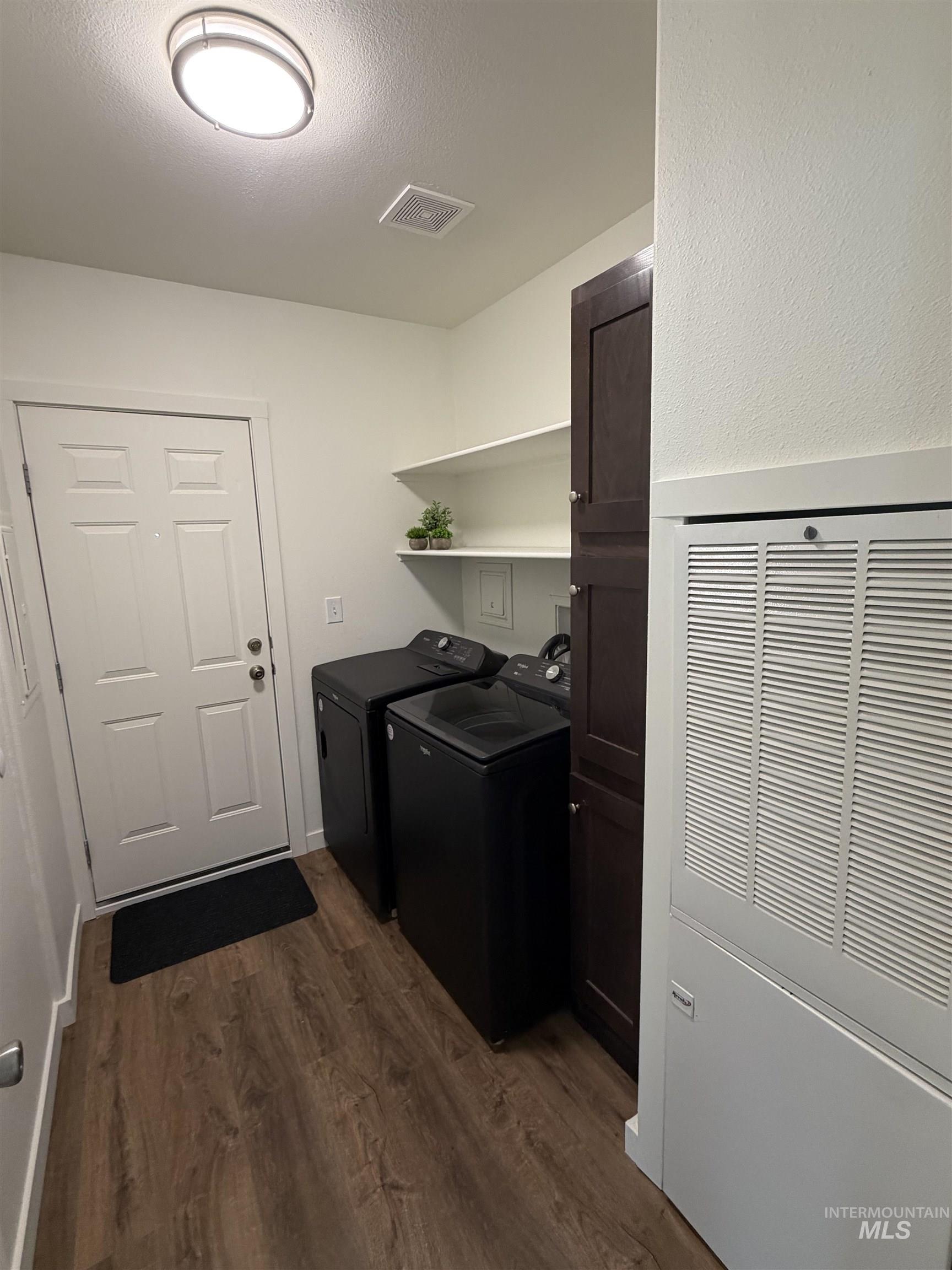 611 North Timathy Road Boise, ID 83713 - Photo 18 of 28 Wood-finish flooring, overhead lighting fixture, white paneled door, built-in shelving, and dark wood-finish cabinetry