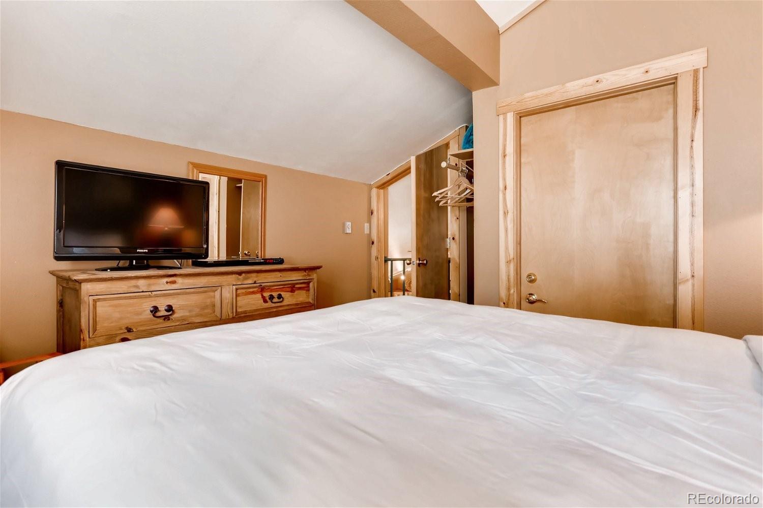 1937 Soda Ridge Road, Unit 1126 Dillon, CO 80435 - Photo 22 of 42 a bedroom with a bed and a flat screen tv