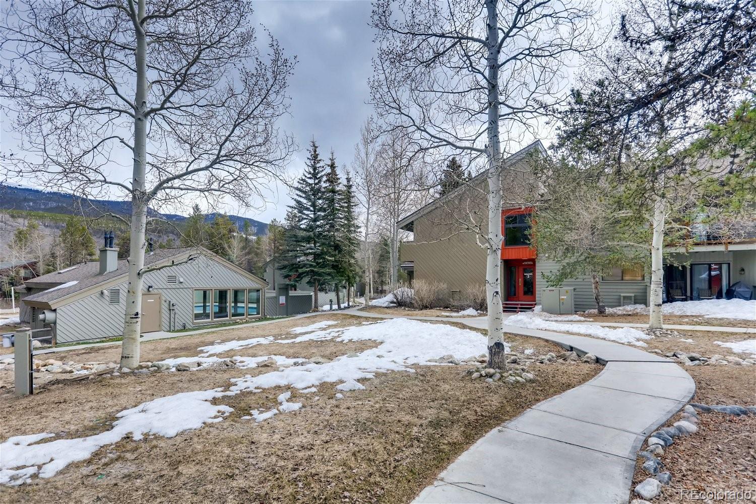 1937 Soda Ridge Road, Unit 1126 Dillon, CO 80435 - Photo 39 of 42 a front view of a house with a dirt yard and a large tree