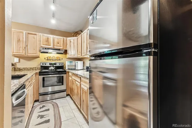 a kitchen with stainless steel appliances a refrigerator sink and stove