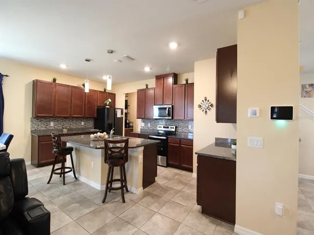 a kitchen with stainless steel appliances granite countertop a stove refrigerator and microwave