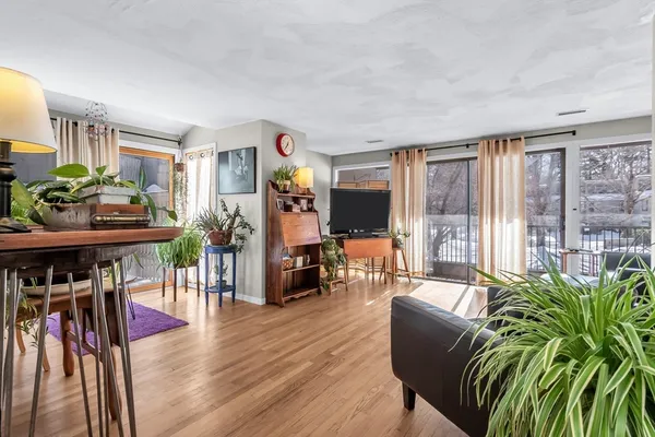 a living room with furniture a flat screen tv and a floor to ceiling window