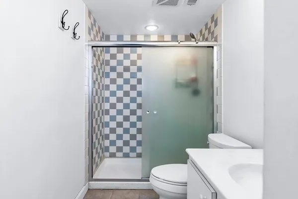 a bathroom with a toilet a sink and shower