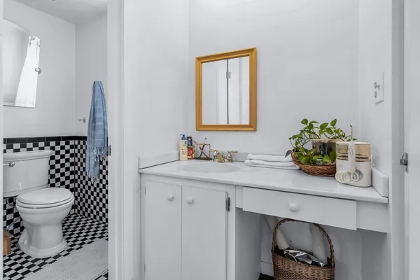 a bathroom with a sink a toilet and a mirror