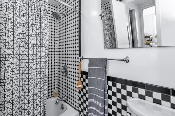 a bathroom with a black and white checkered floor